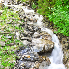 waterfall through the stones and grass, silky water