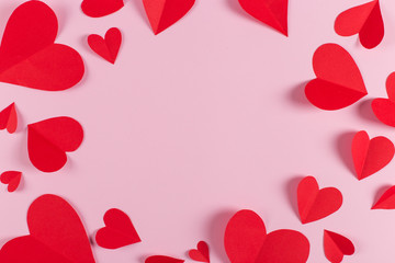 Red hearts are handmade on pink background. Preparation for Valentine's Day with a place for text. Copy space.