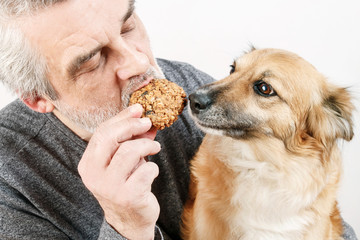 Man feeding his dog with an oatmeal cookie.