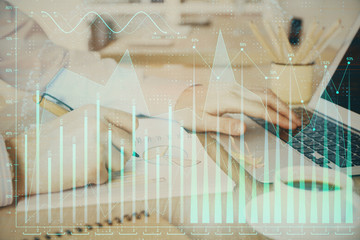 Multi exposure of stock market graph with man working on laptop on background. Concept of financial...
