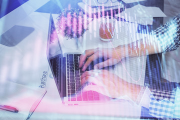Double exposure of graph with man typing on computer in office on background. Concept of hard work.