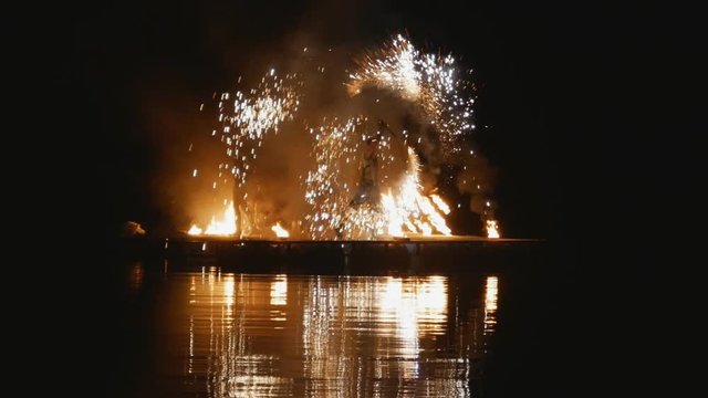 Fire show. artists dance with fire at night on water. a beautiful reflection in the water. Fireworks
