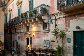 Evening view of the city of Matera, Italy, with the colorful lights highlighting patios of sidewalk cafes in the Sassi di Matera a historic district in the city of Matera. Basilicata. Italy