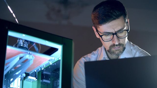Male engineer works with 3D printer. 3d printing industry engineer works in 3d printing lab.