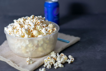 Bowl with salted popcorn on a black table, selective focus