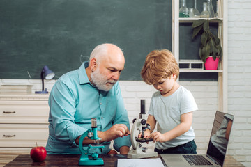 Funny little child having fun on blackboard background. Family generation and relations concept. A...