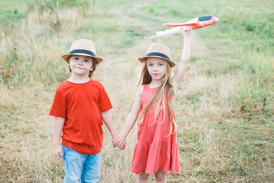 Childhood dream imagination concept. Active children concept. Smiling children having fun with toy airplane in autumn park. Funny kids couple in the autumn park. Summer at countryside.