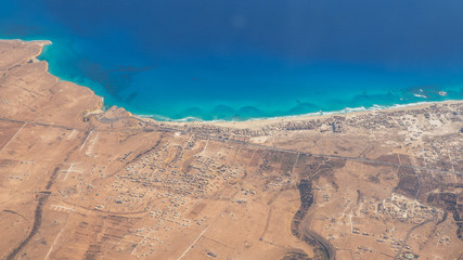 Earth's line. A perspective of the ground's colors and shapes. Aerial view of the Egyptian coast overlooking the Mediterranean sea. View from the airplane window. Sea with fantastic turquoise colors