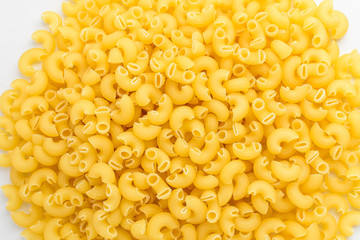 Dried cornetti rigati Italian pasta displayed randomly on a white table, ready to be cooked, isolated on white background,  top view or flat lay photograph of healthy food 