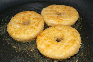 Three minced chicken cutlets are fried in a pan in vegetable oil. Close up.