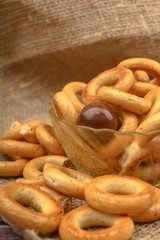 Small bagels, brown sugar and ceramic dishes on a wooden background close-up.