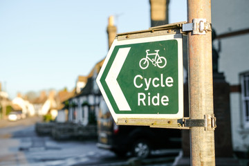 Detailed view of a newly installed Cycle Ride metal sign attached to a metal post near the centre of a rural village. Part of a long cycle route.