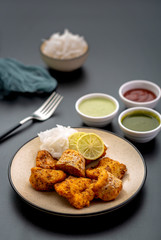 Boneless fried fish served with green sauce and dip