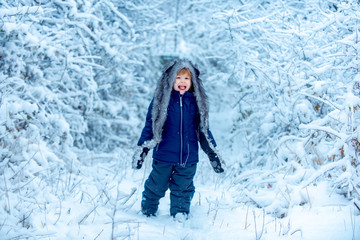 Fototapeta na wymiar Merry Christmas and happy holidays. Winter child. Little child in snow field. Enjoying nature wintertime. Concept winter Kids and nature.