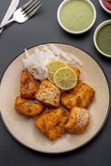 Boneless fried fish served with green sauce and dip