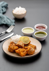 Boneless fried fish served with green sauce and dip