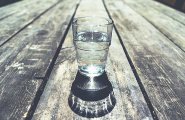 Close-up of one glass of clear water on wooden table
