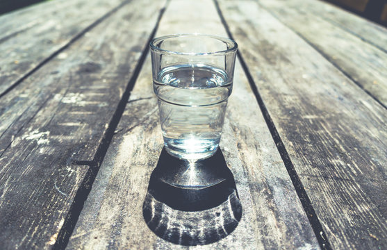 Close-up Of One Glass Of Clear Water On Wooden Table