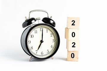 “2020” wordings on wooden blocks with alarm clock againts white background 
