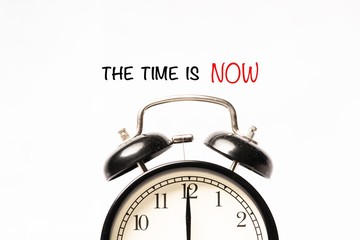 “THE TIME IS NOW” wordings with alarm clock against white background