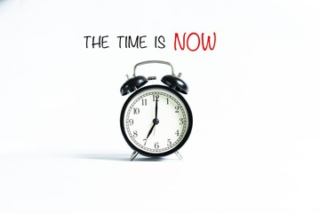 “THE TIME IS NOW” wordings with alarm clock against white background