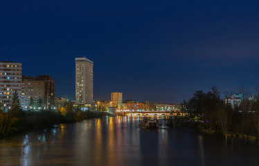 Fototapeta na wymiar city from the river at night with illuminated bridge