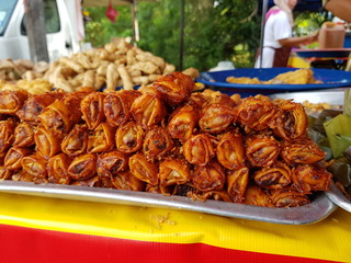 Fried chili spring rolls on display for sale by street vendor