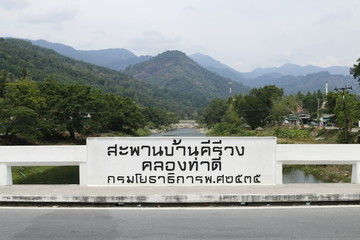Baan Khiriwong bridge with sign named In Thai Language”Baan Khiriwong Bridge, Tha Dee Canal, was...