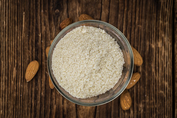 Some Almond Flour on a vintage wooden table (selective focus; close-up shot)