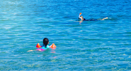 A child swims in a mask in the sea, kid activity