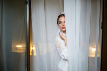 Fototapeta na wymiar beautiful bride in a wedding morning in a bathrobe and veil