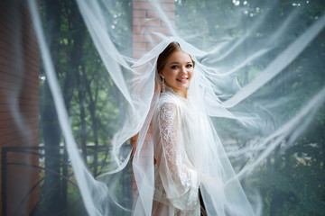 beautiful bride in a wedding morning in a bathrobe and veil