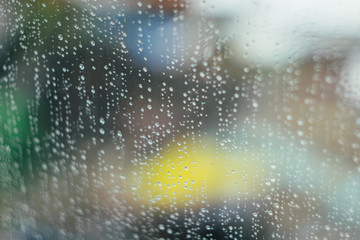 Raindrops at window glass. Defocused abstract background.