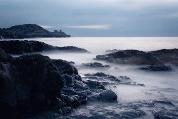 The Mumbles with it's a lighthouse as seen from Bracelet Bay on the Gower Peninsular Wales, UK