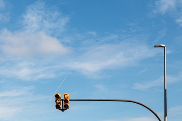 dos semaforos en un solo poster con el cielo azul con nubes de fondo. luces roja, verde y amarilla. encendido. señales de trafico, señalización. stop, no seguir, cuidado, adelante.