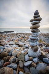 Stack of stones against blurred seascape on a beach swansea wales, space for text. Zen concept
