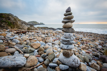 Stack of stones against blurred seascape on a beach swansea wales, space for text. Zen concept