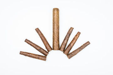 Big and small cigars twisted from sheets of tobacco on white background.