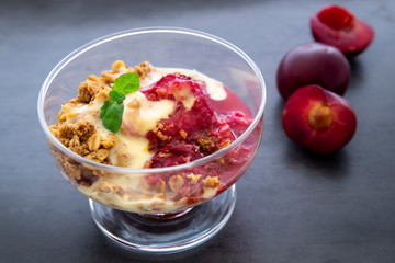 Fresh bright red plum crumble in the dessert bowl