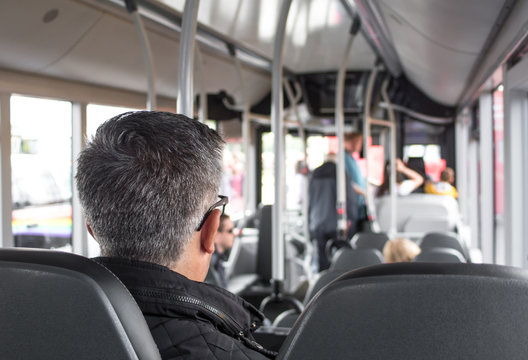 Rear View Of Man Sitting In A Seat On A Public Bus.  Selective Focus