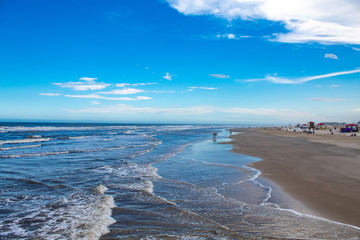 Mar bravio com ondas e o céu azul com nuvens na Praia dos Molhes, cidade de Torres, estado do Rio Grande do Sul, Brasil