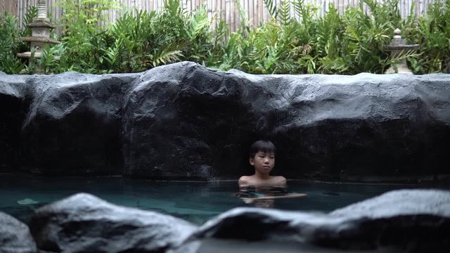 k Young asian boy relax in hot water onzen