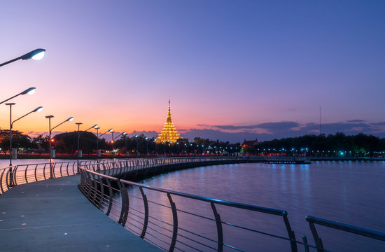 In Khon kaen twilight time at Bueng Kaen nakhon with Wat Phra Mahathat Kaen Nakhon, travel concept, lifestyle with copy space.