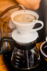 Close-up drip coffee. Barista pouring water over the coffee powder.