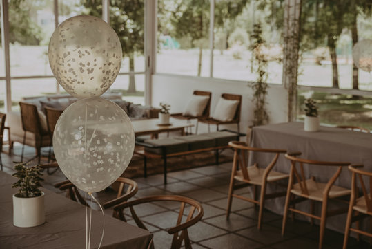 Decoracion Para Fiesta De Dia Con Globos, Sillas Y Mesas De Madera.