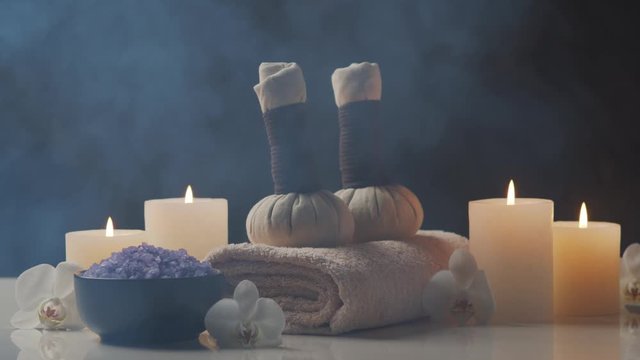 Aromatherapy, oriental massage and spa treatment. Relaxation composition of towels, candles, flowers, stones and herbal balls.