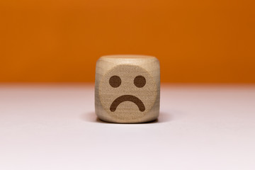 Pictogramme smiley triste sur cube en bois