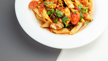 Penne pasta with a rich tomato sauce and slices of British pork sausage topped with Cheddar cheese