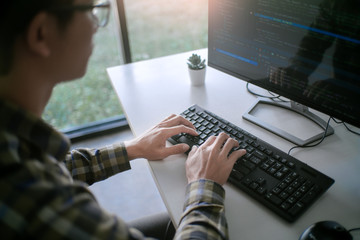 Pensive programmer working on desktop pc programming code technologies or website design at office...