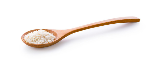 Japanese rice in wooden spoon on white background